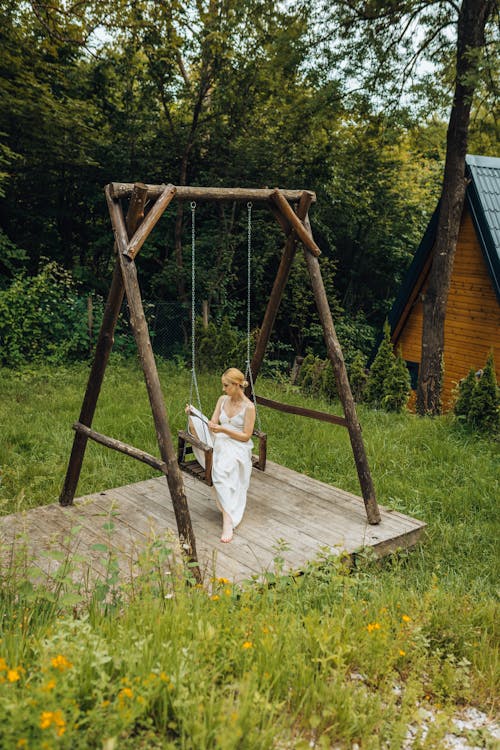 Woman Sitting on Swing in Forest