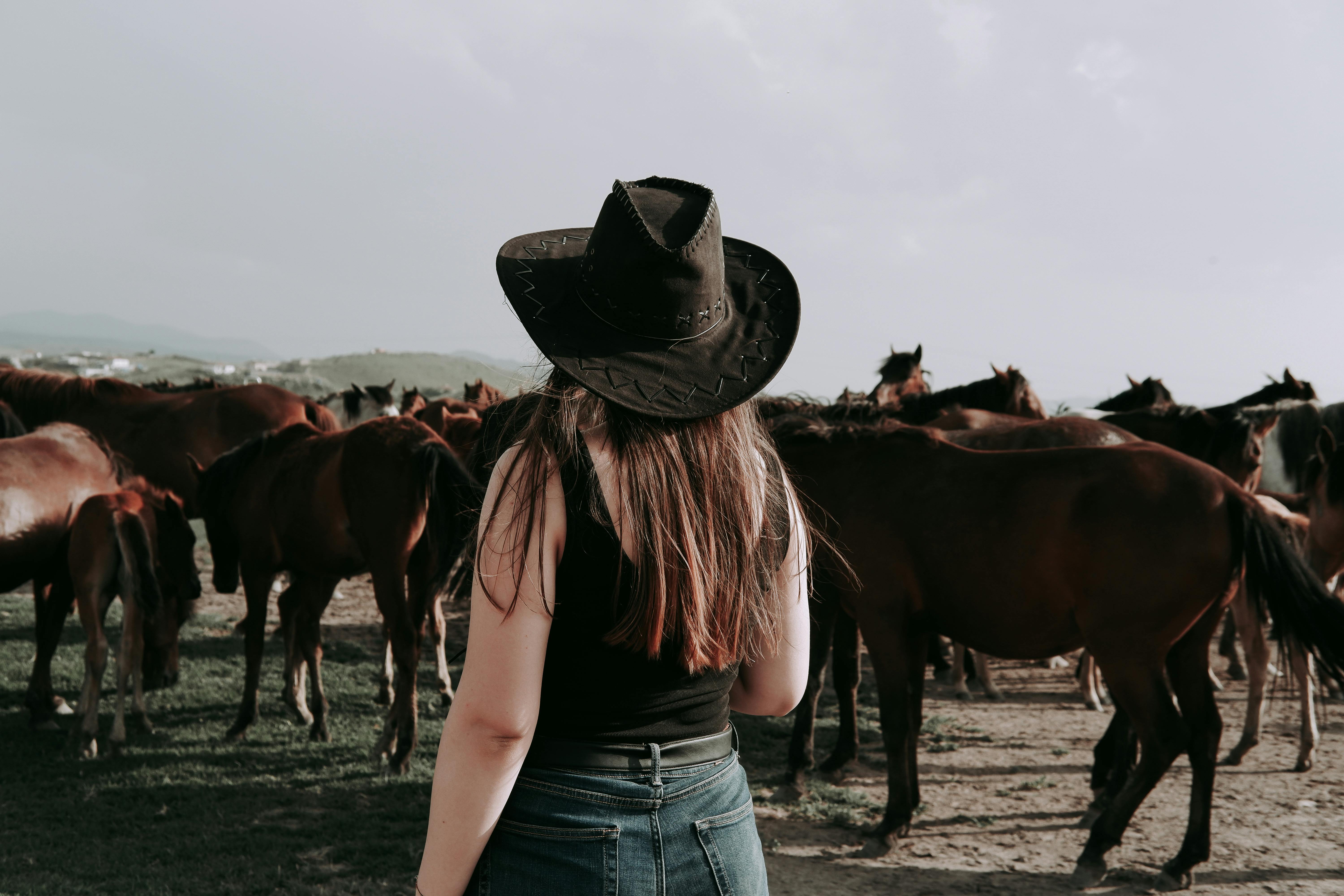 woman in a cowboy hat at a horse farm