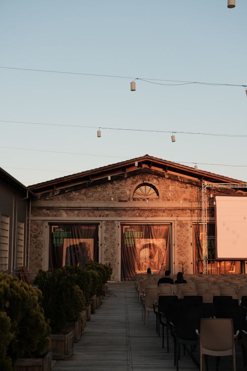 Free Rustic outdoor venue with wooden seating and lighting at sunset, perfect for events. Stock Photo