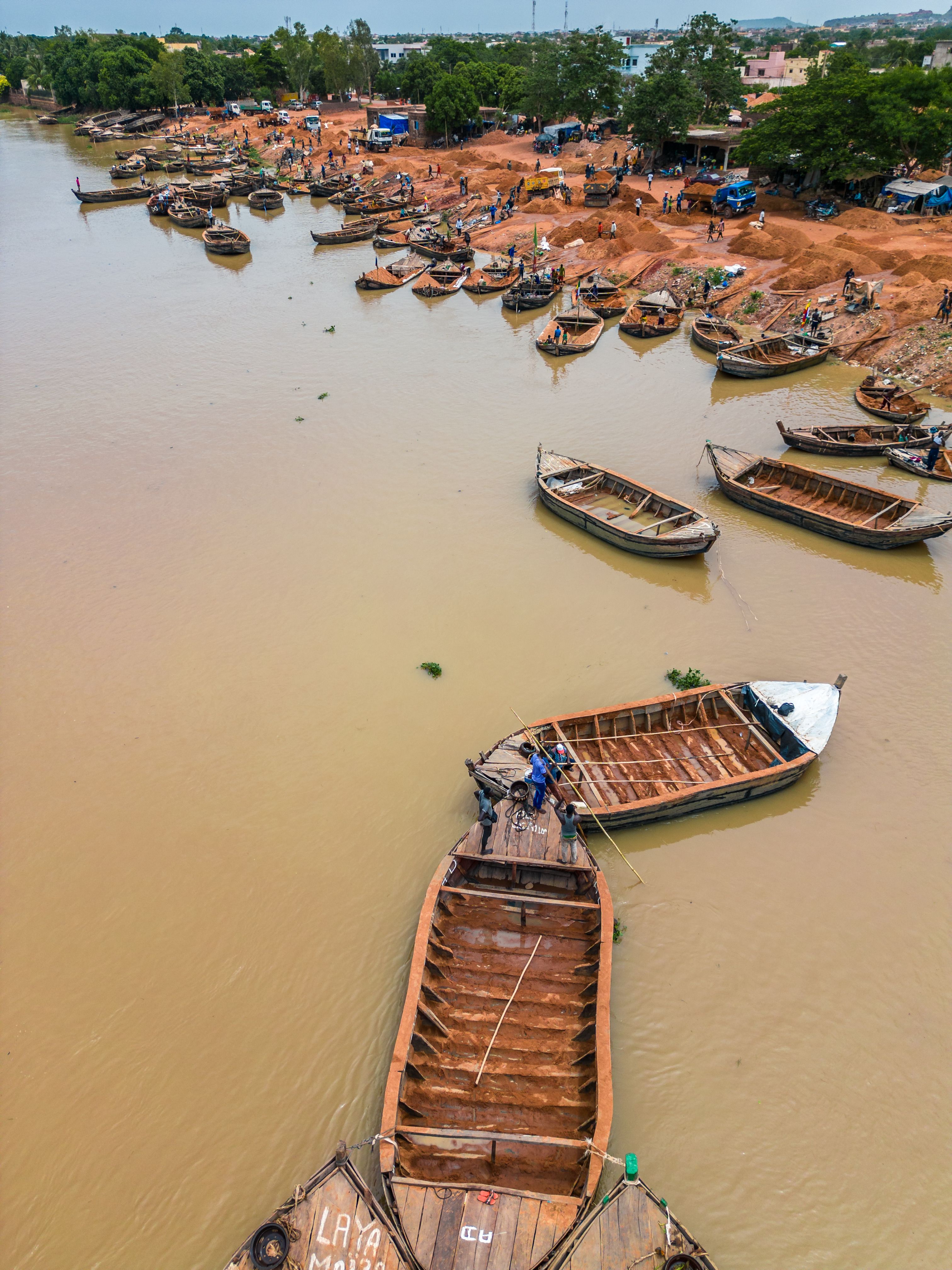 Aerial view of traditional boats on the Niger River in Bamako, Mali, capturing local life.