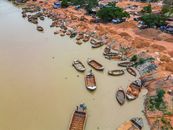 Aerial view of wooden boats along the Niger River in Bamako, Mali. Busy riverbank activity.