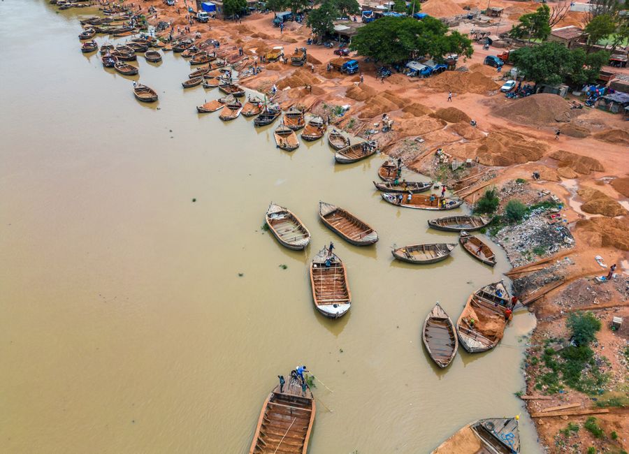 Aerial view of wooden boats along the Niger River in Bamako, Mali. Busy riverbank activity.