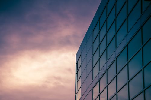 Free A sleek modern skyscraper reflecting the colorful twilight sky, emphasizing urban architecture. Stock Photo