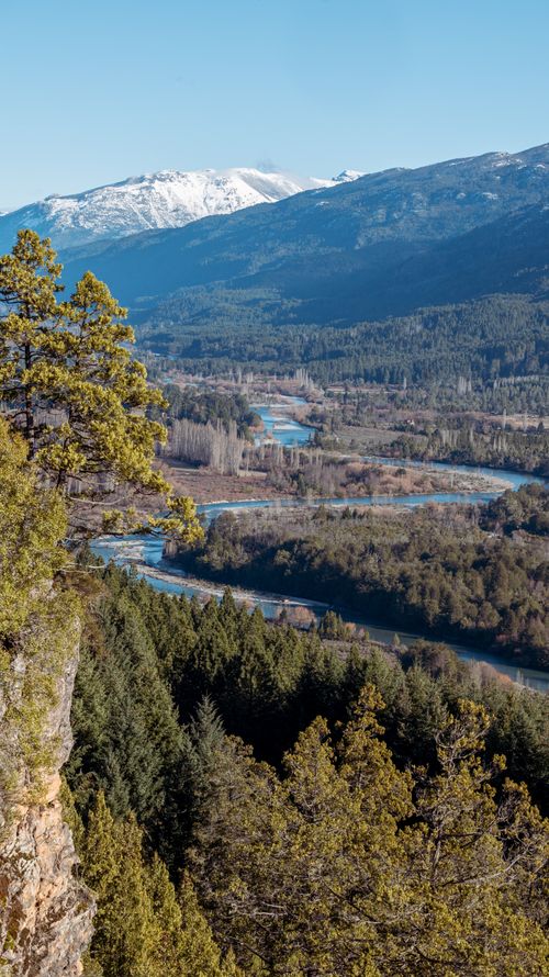 Free A breathtaking aerial view of a winding river in a lush mountain valley. Stock Photo