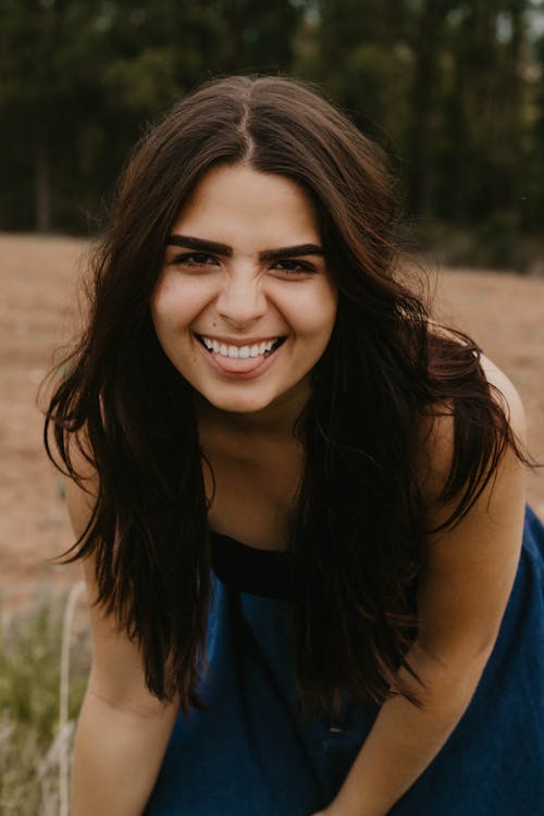 Smiling Brunette Woman in Blue Dress