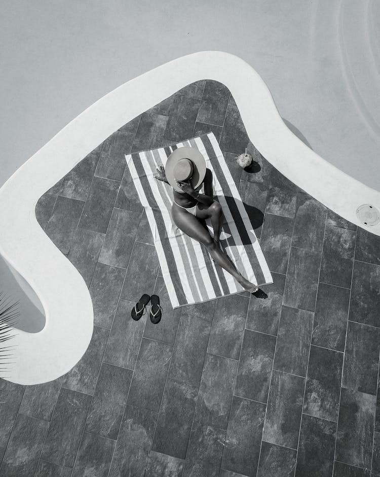 Woman Sunbathing By The Pool 