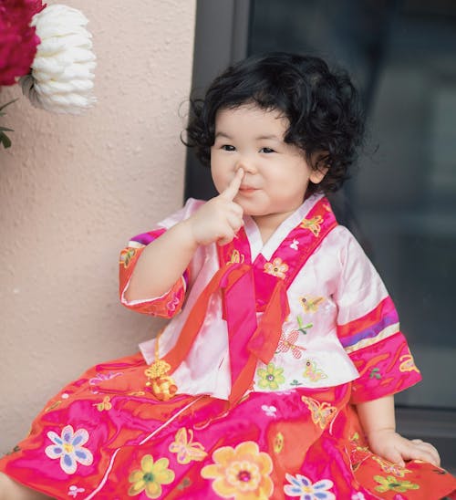 Little Korean Girl in Traditional Clothing Pointing at her Nose 