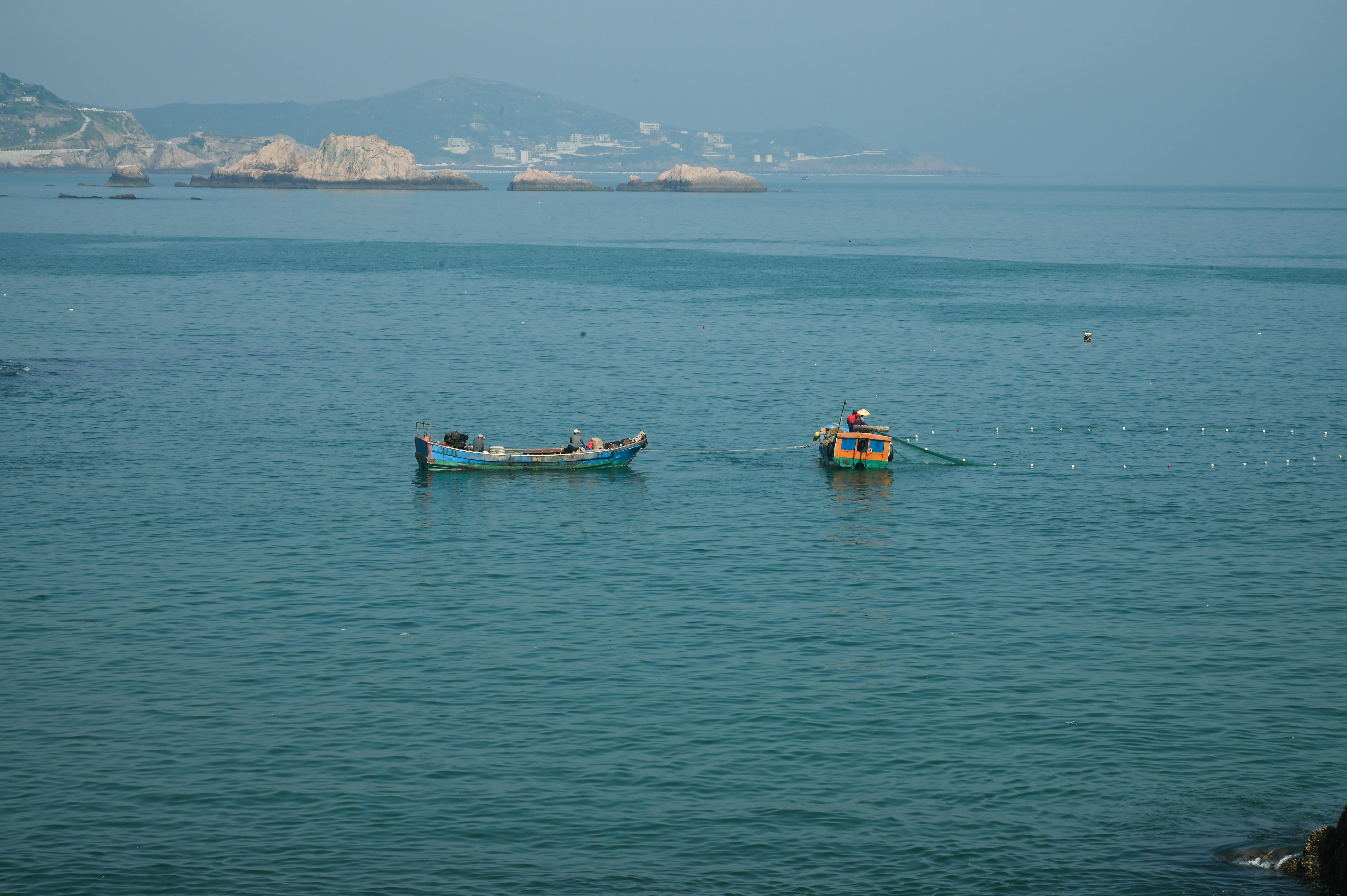 Men Throwing a Fishing Net in Sea at Dusk · Free Stock Photo