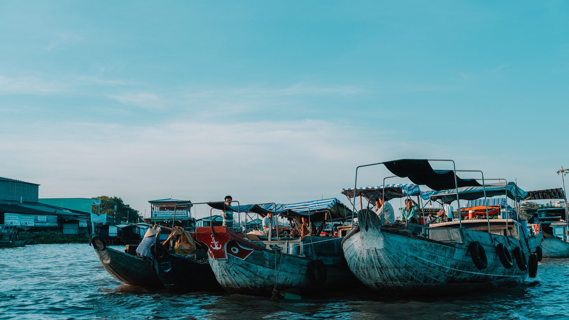 Serene view of moored boats in a bustling harbor under a clear sky, perfect for travel enthusiasts.