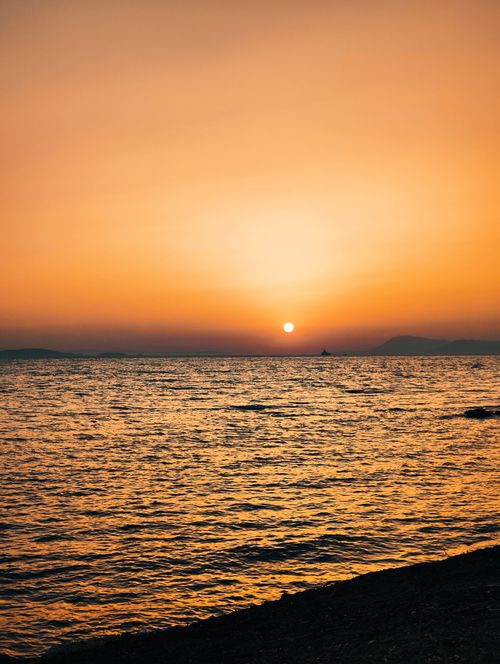 Free Beautiful sunset over the Aegean Sea in Didim, Türkiye with a vibrant orange sky. Stock Photo