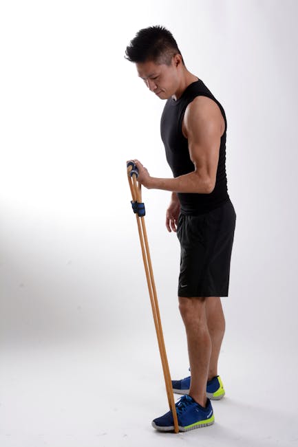 Man in Black Tank Top Holding Brown Stretching Rope