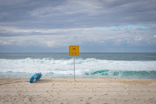 Prancha De Surfe Azul Na Linha Costeira Próxima à Sinalização