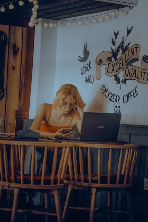 Woman Working on a Laptop in a Coffee Shop