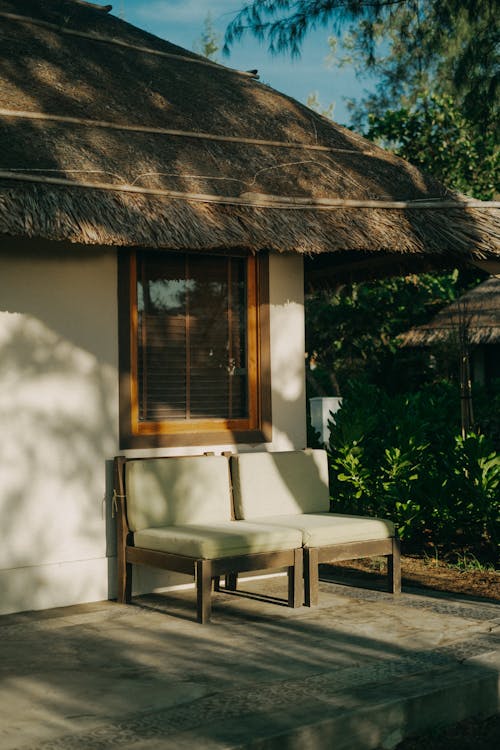 Chairs in Front of a Residential House with Thatched Roof 