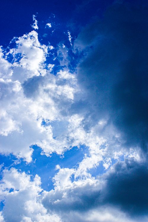 Free A dramatic cloudscape featuring white and dark clouds in a vibrant blue sky, captured in Makassar, Indonesia. Stock Photo