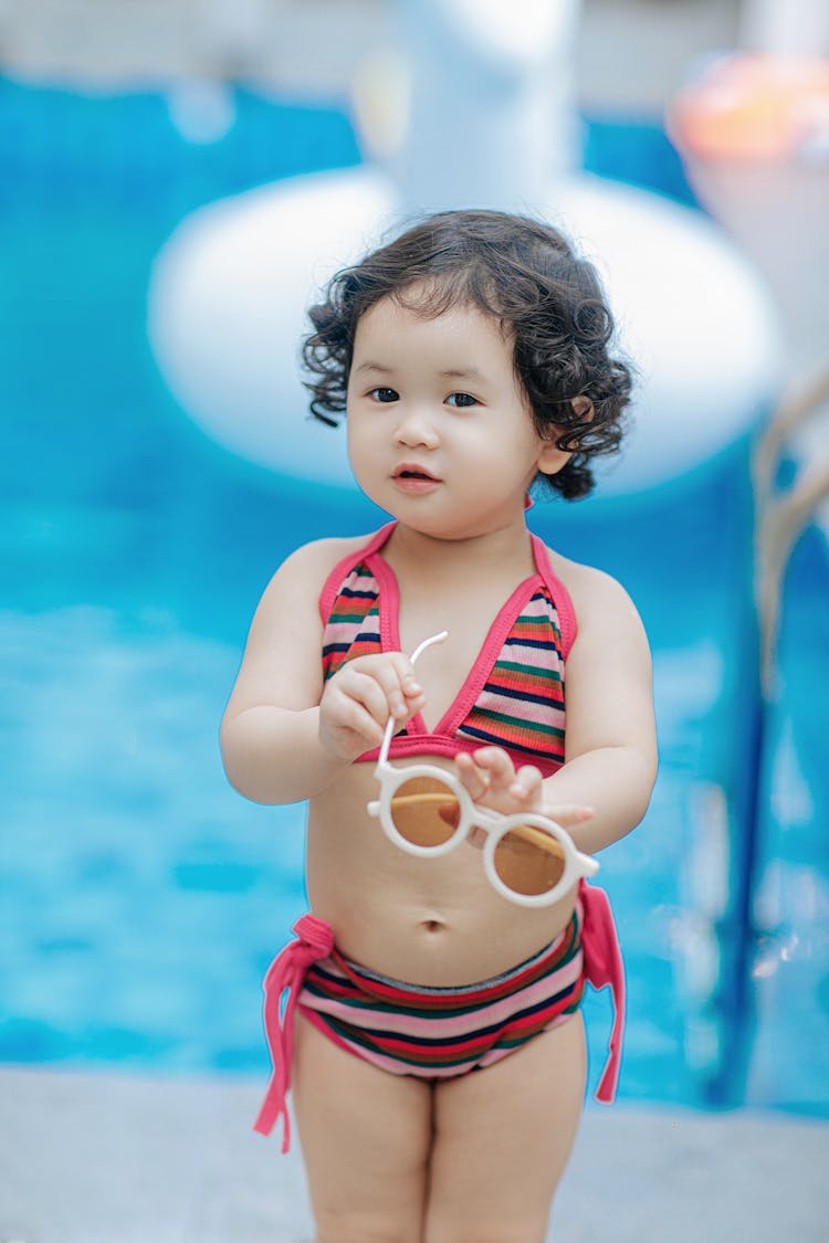 A Little Girl In A Bikini By The Pool