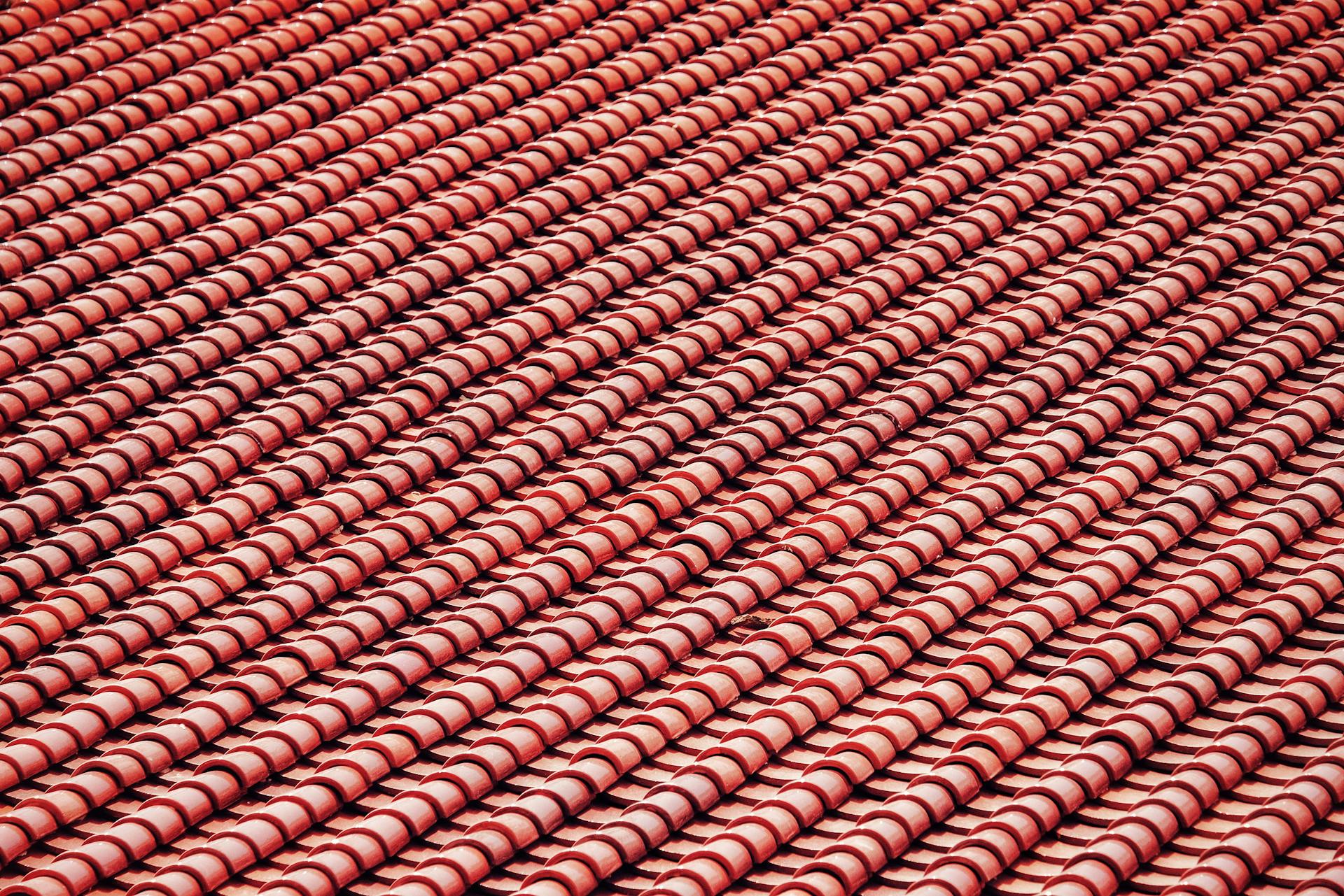 Detailed close-up of red roof tiles showing uniform design and pattern.