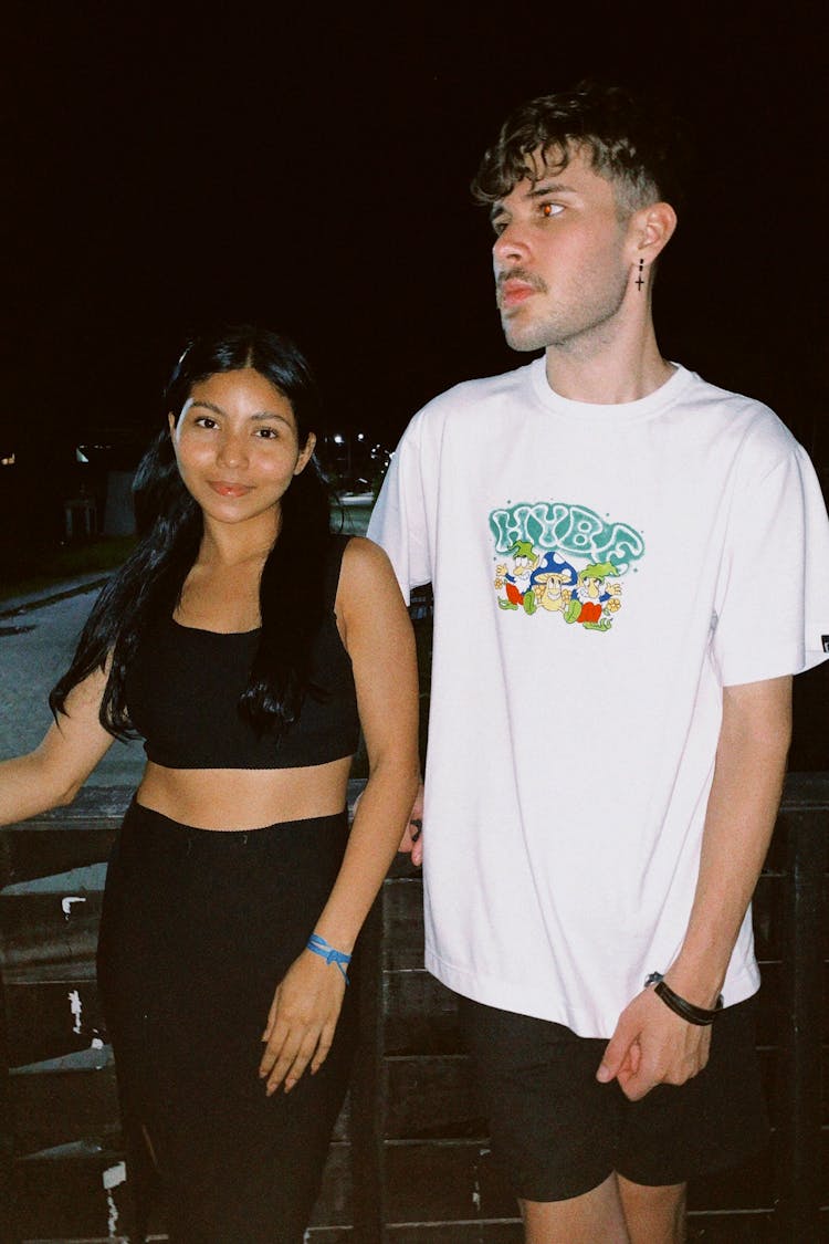 Young Brunette Woman And Man Posing On A Street At Night