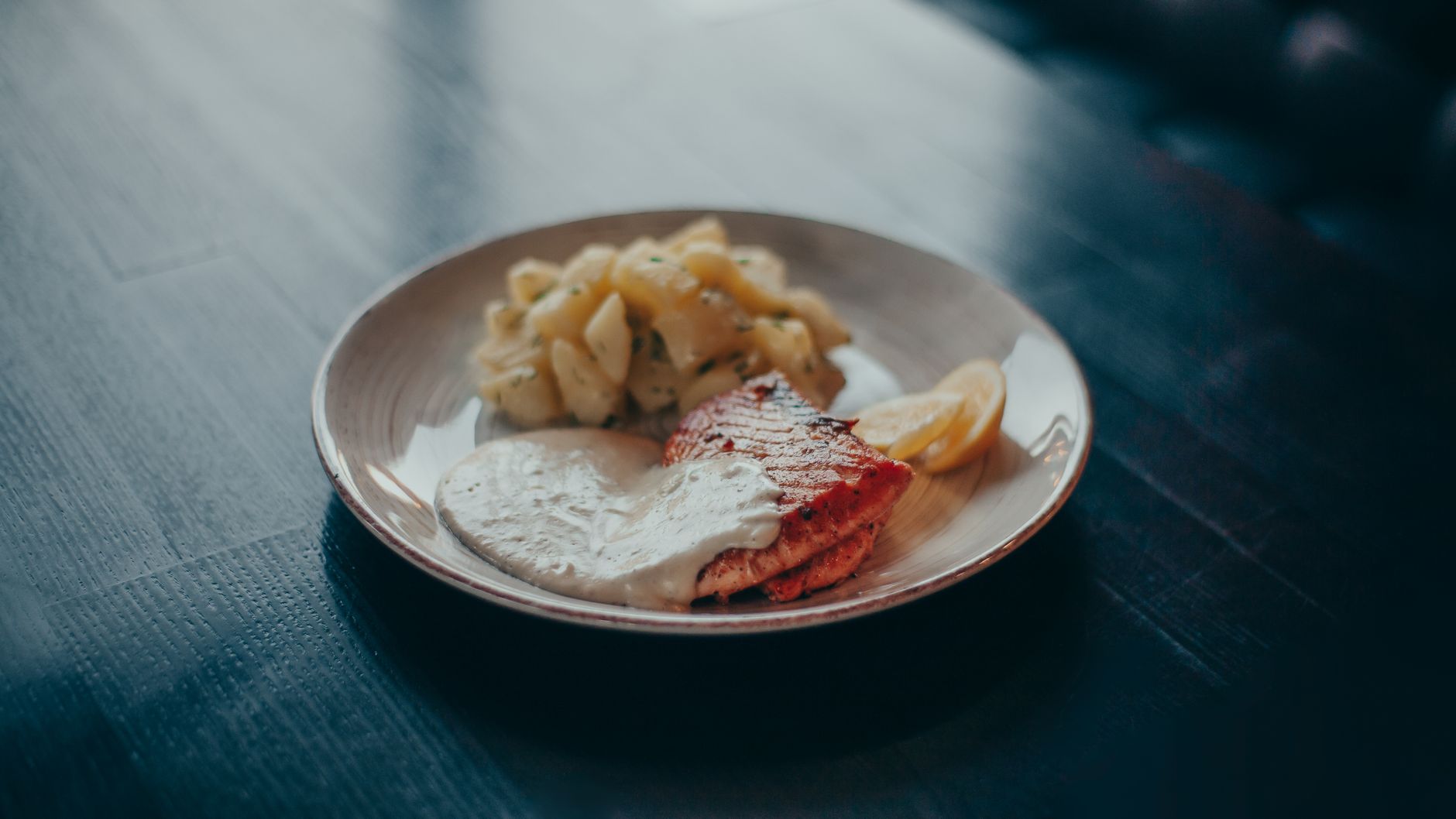 Delicious grilled salmon served with a creamy sauce and potatoes, perfect for a healthy dinner.