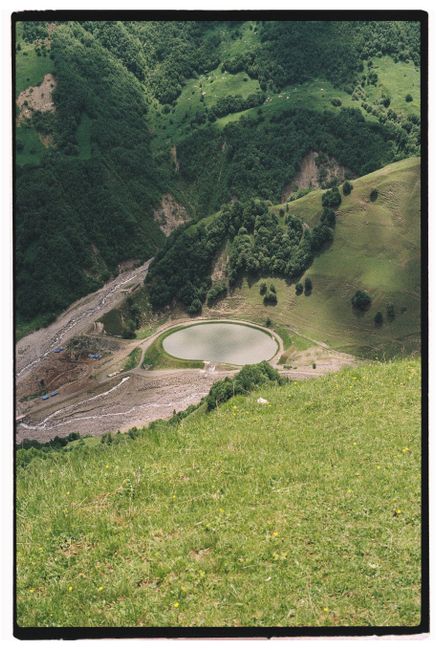 A breathtaking aerial shot of a reservoir nestled in lush green mountains, showcasing nature's beauty.