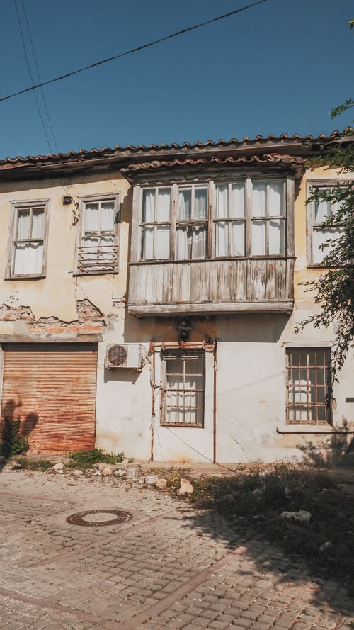 Free A neglected, vintage townhouse showcasing decay amidst an urban landscape. Stock Photo