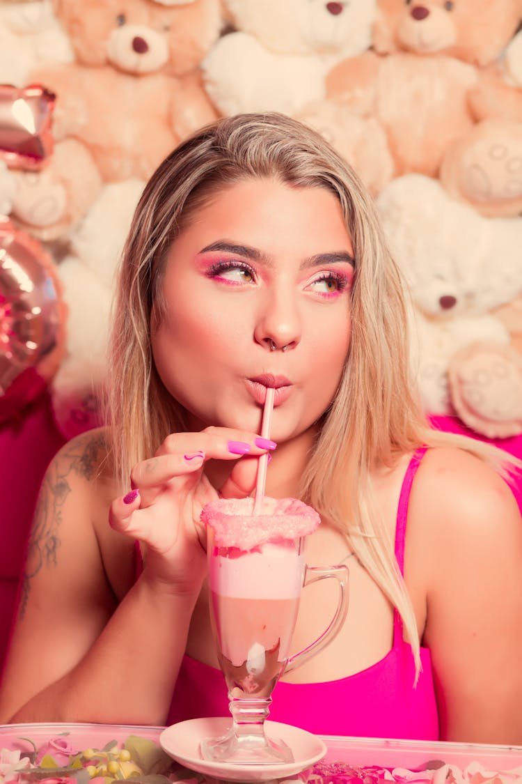 Woman Drinking Smoothie At Birthday Party