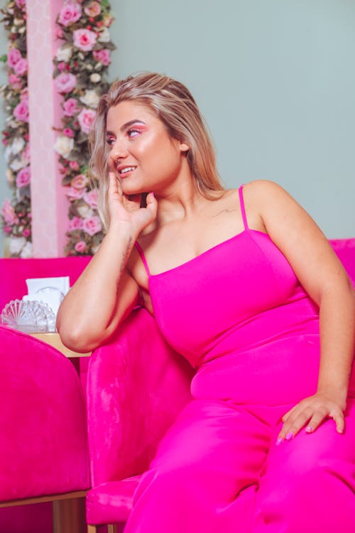 Woman in Pink Suit Sitting on Couch