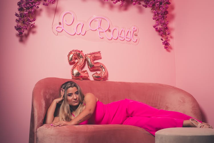 Woman In Magenta Romper Lying On A Sofa