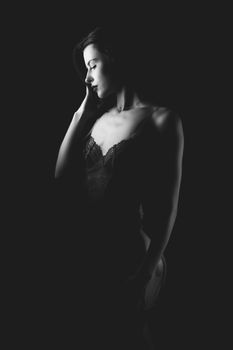 Striking black and white portrait of a woman in lingerie, showcasing elegance and grace.