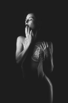 Artistic black and white portrait of a woman in lingerie, captured in a studio setting.