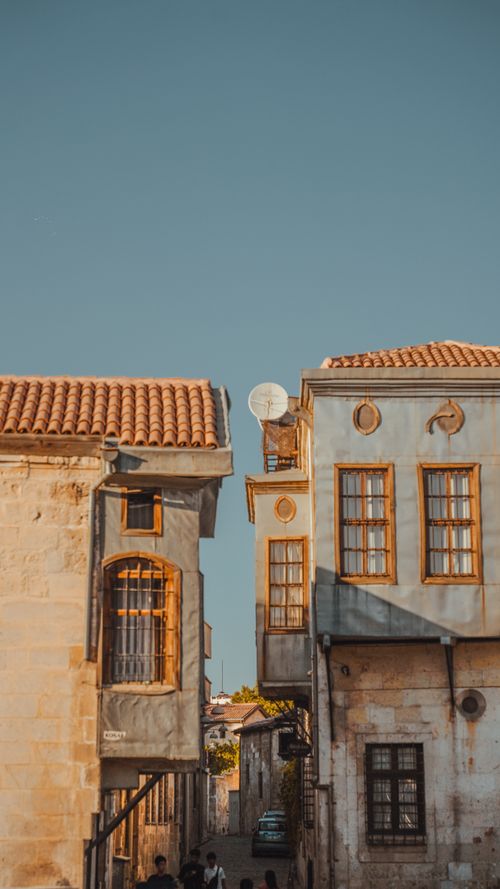 Free Explore the rustic charm and classical architecture in a sunny, narrow city alleyway. Stock Photo