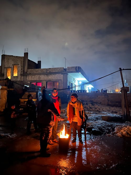 People around fire in Syrian refugee camp in Lebanon, night shot