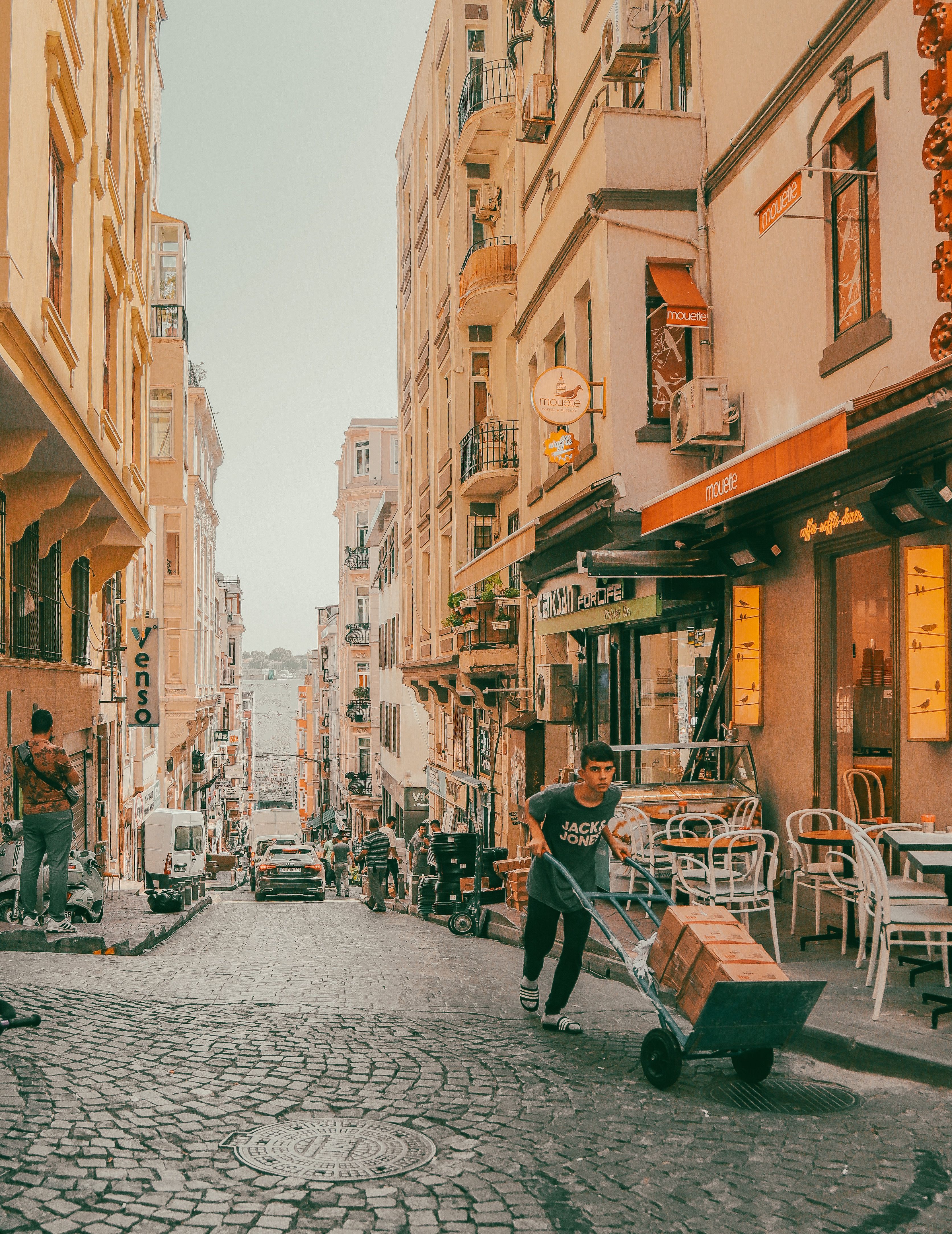 A Cobblestone Street between Apartment Buildings in City · Free Stock Photo