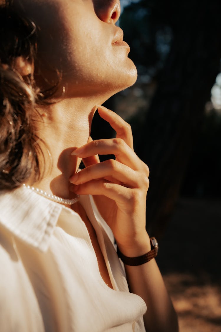 Woman Touching Neck With Pearls