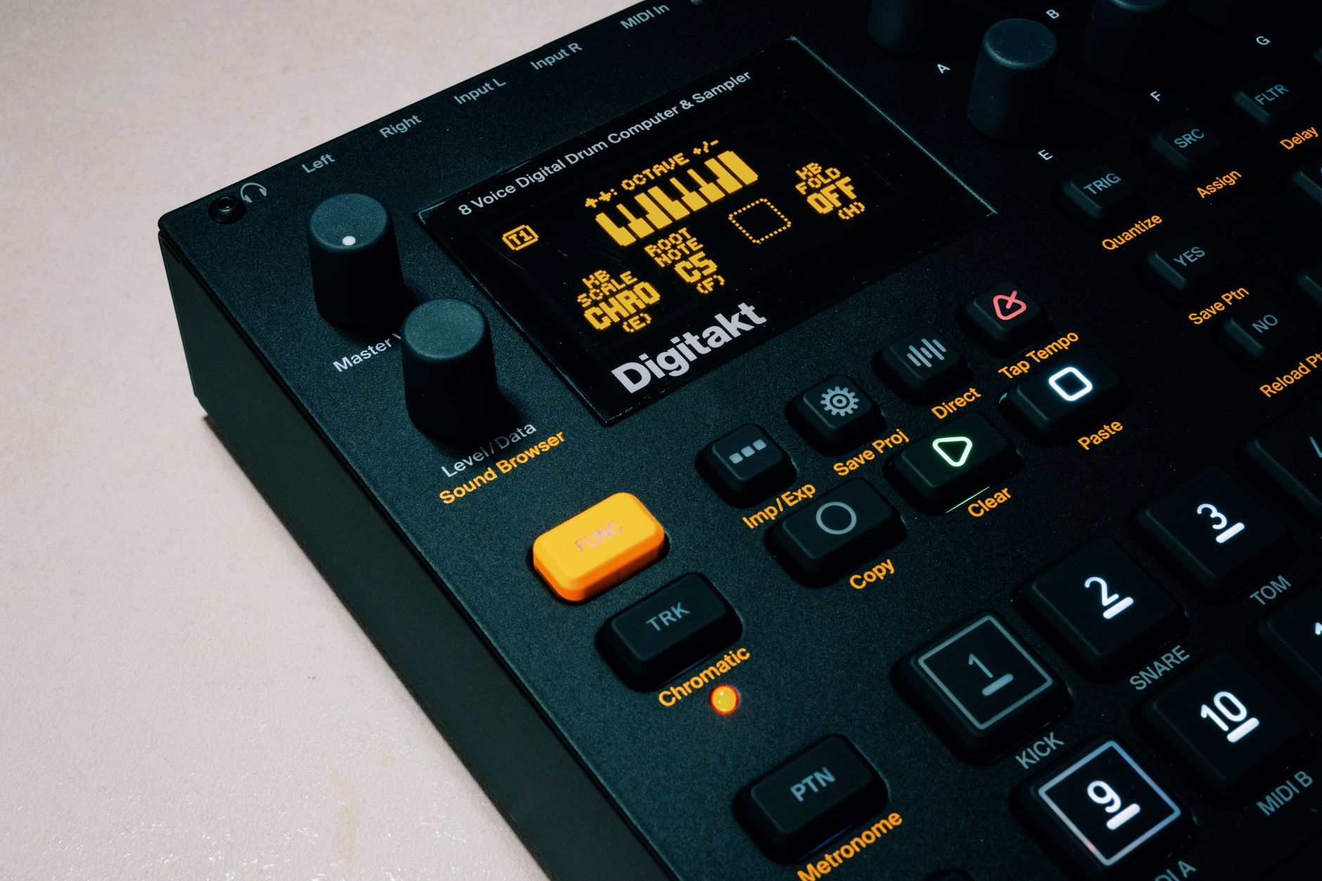 Detailed view of a music production sampler with buttons and display screen.