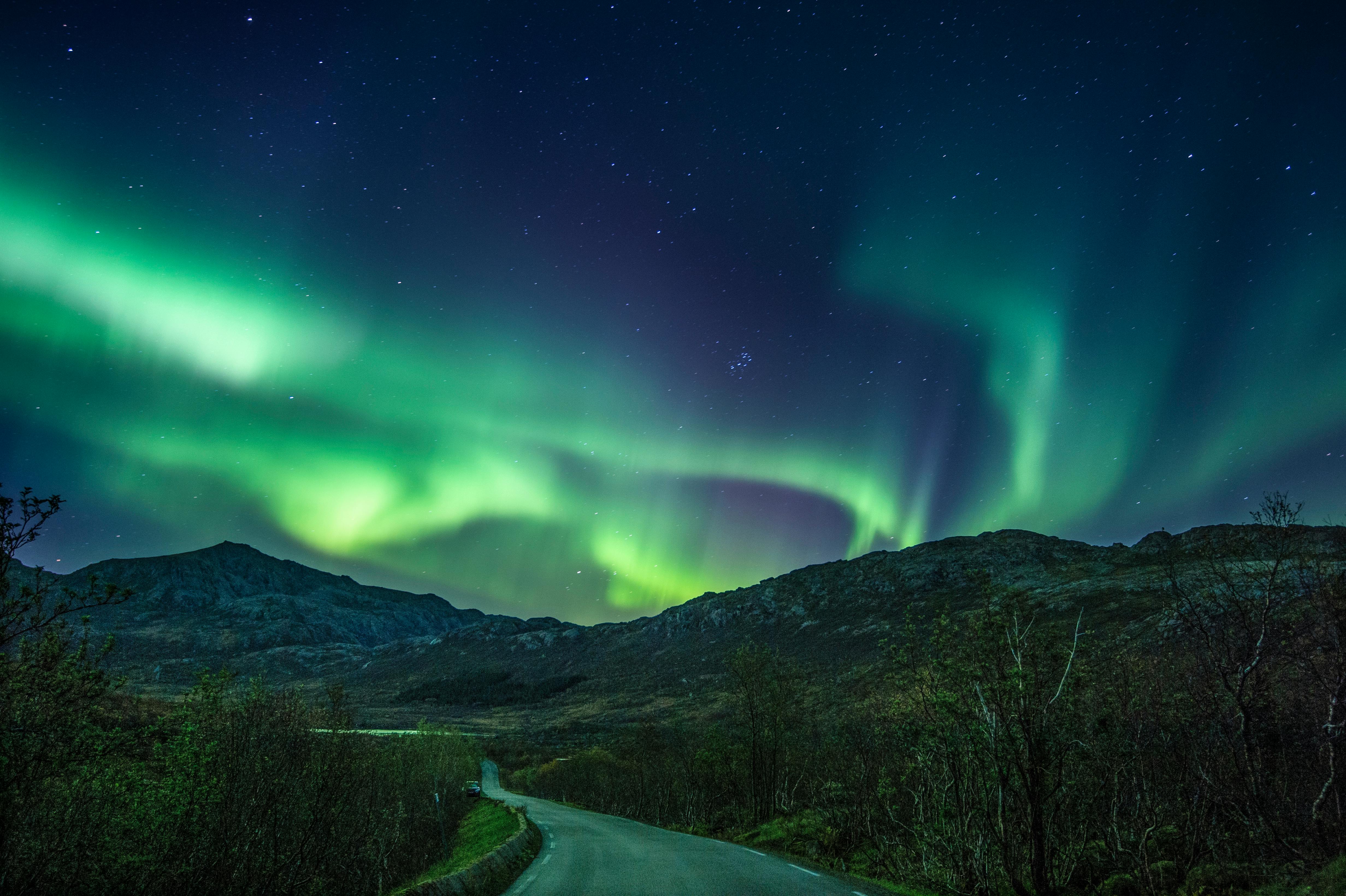 Breathtaking view of the Northern Lights over mountains in Nusfjord, Norway. Perfect for travel and nature enthusiasts.