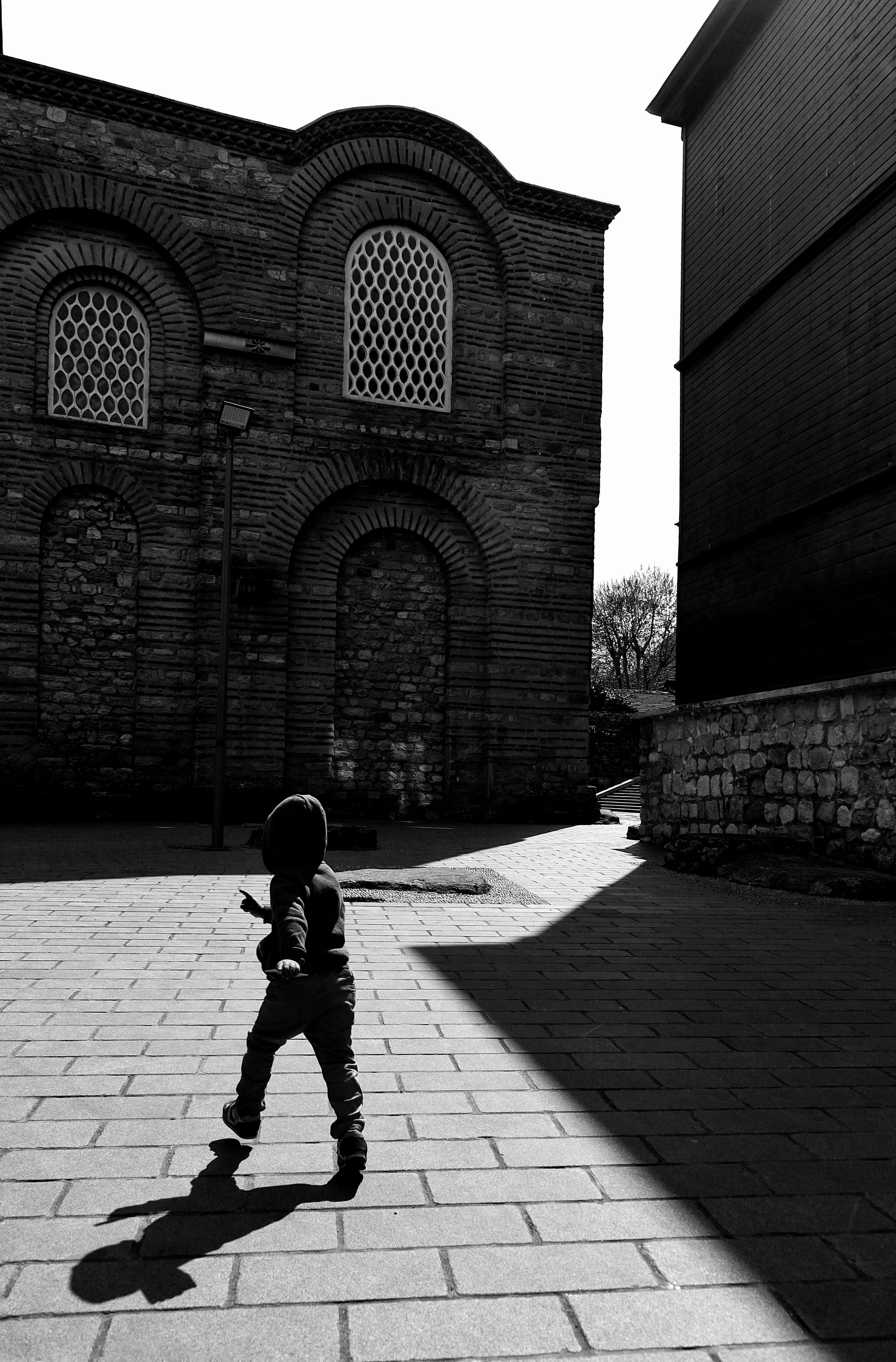 Black and White Photo of a Child Walking on a Old Town Square · Free ...