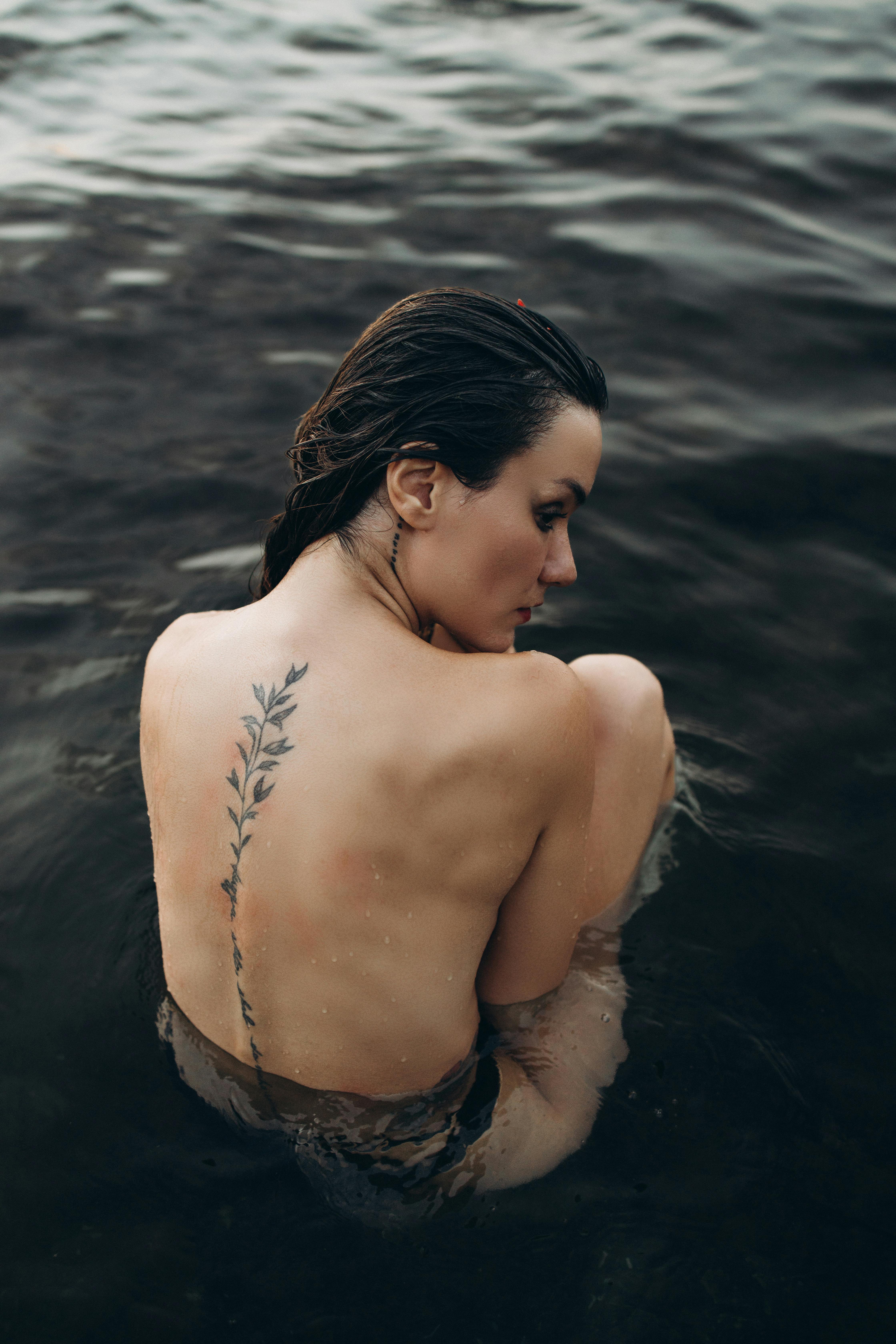 a woman with tattoos in the water