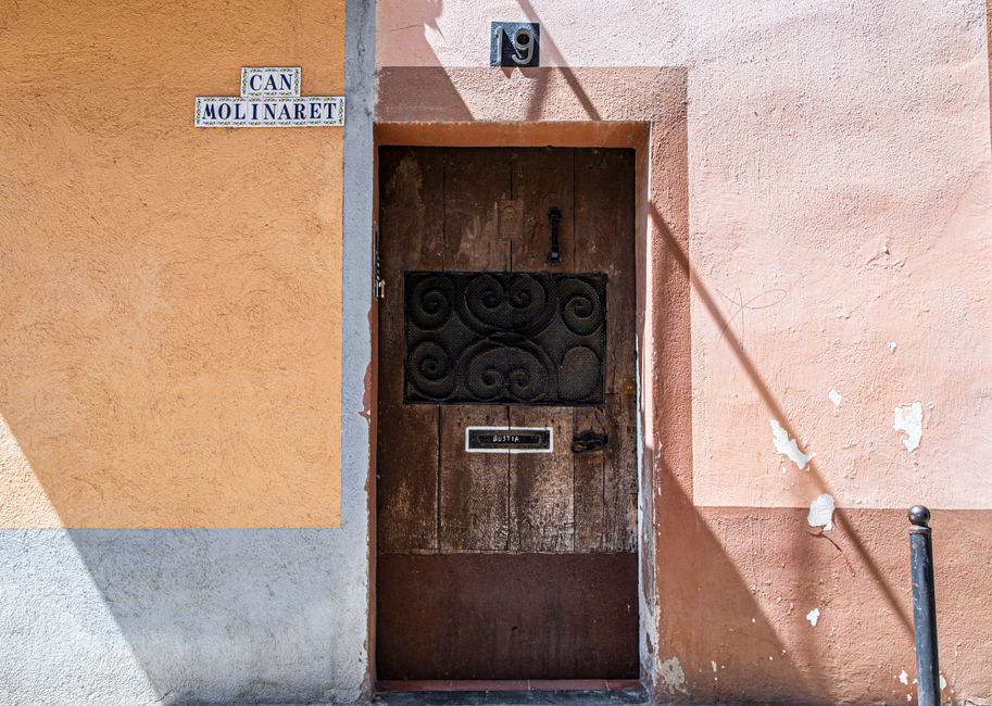 Charming rustic doorway in Besalú, Spain with textured walls and shadow play.