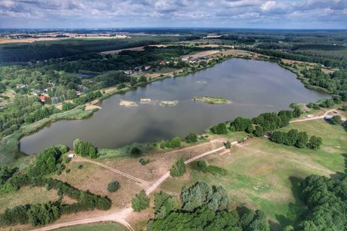 Free Explore a tranquil countryside lake surrounded by lush greenery and rural landscapes from above. Stock Photo