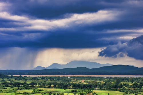 Rain Clouds over a Countryside Landscape with Distant Mountains