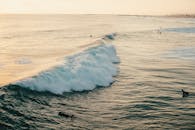 在日落时分，冲浪者在风景如画的加州海岸线上冲浪，这无疑是冒险和旅行的最佳时刻