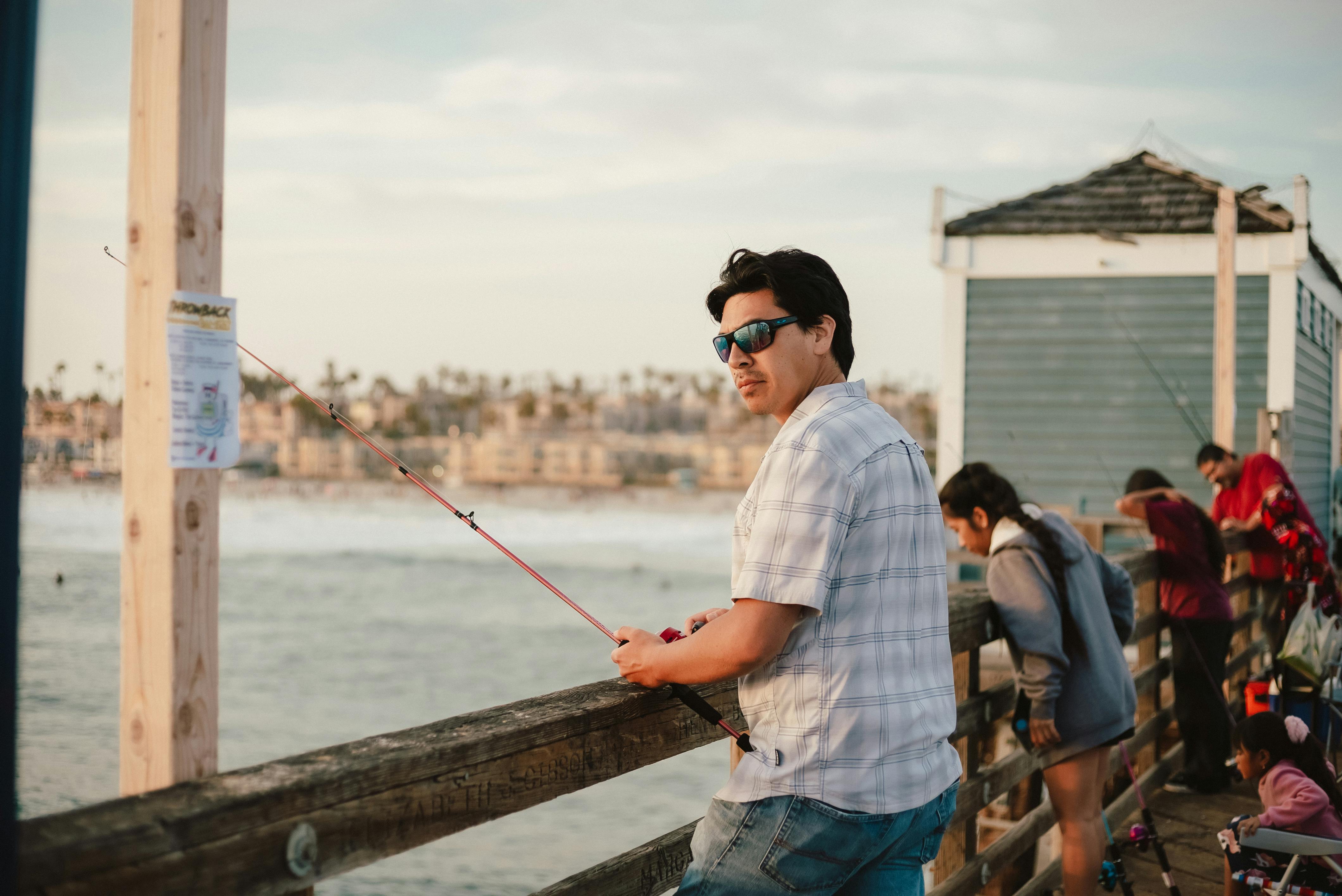 One Fishing Rod Hanging Off A Pier Photograph by Cavan Images - Pixels