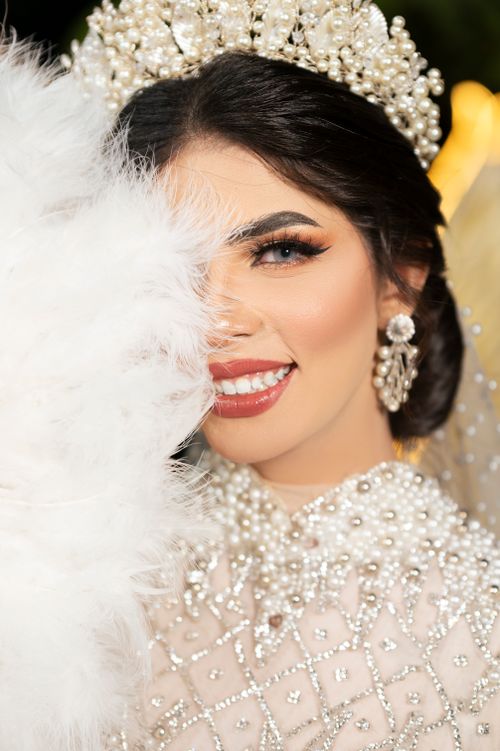 Free Close-up of a smiling bride in glamorous pearls and white feather accessory. Stock Photo