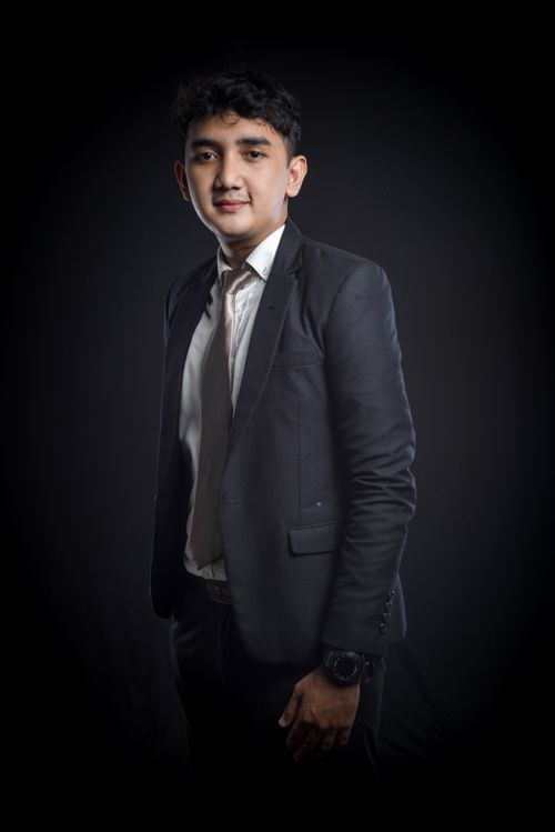 Free Studio portrait of a young professional man in a suit against a black background. Stock Photo