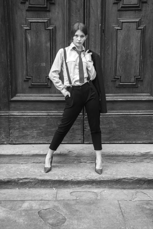 Free Stylish woman in formal wear posing against a vintage wooden door. Stock Photo