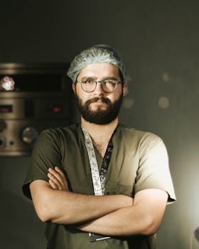 Portrait of a doctor in green scrubs with arms crossed, exuding confidence indoors.