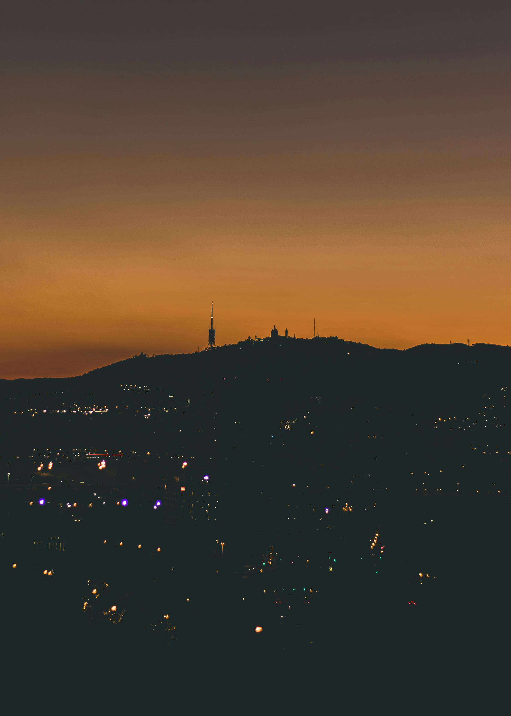 美丽的城市剪影映衬着充满活力的橙色日落天空，捕捉了暮色的宁静