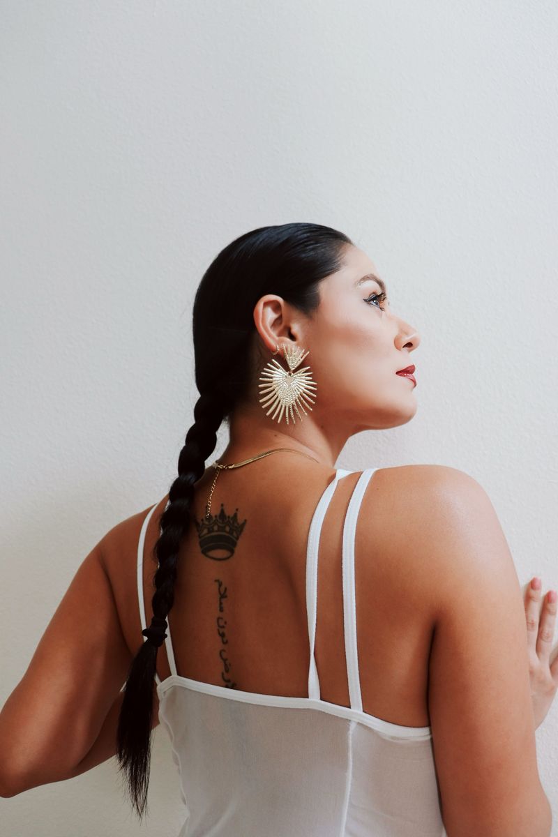 Brunette woman with a braid posing on a white background