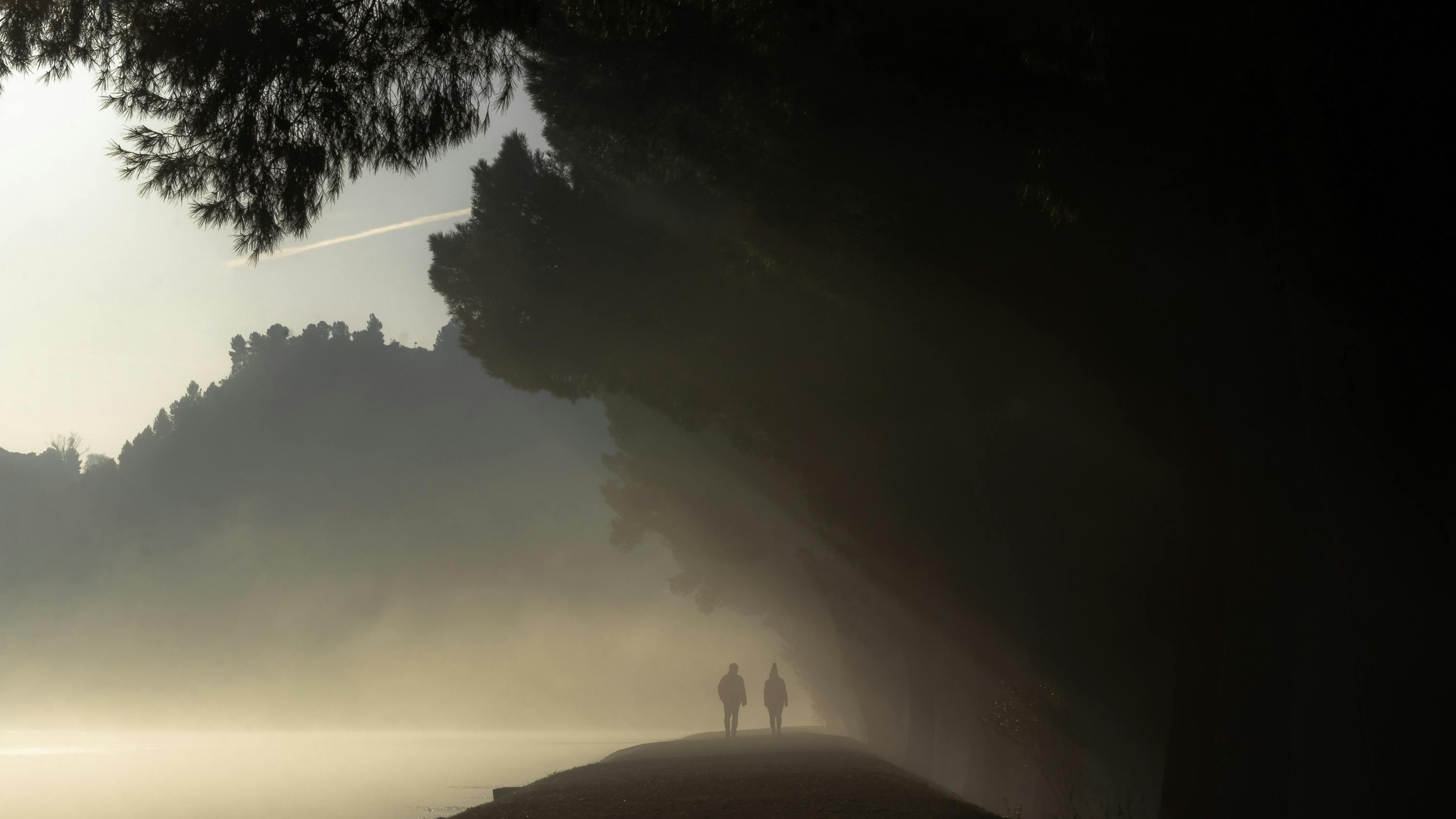 Women running on a beach in active swimwear at sunset